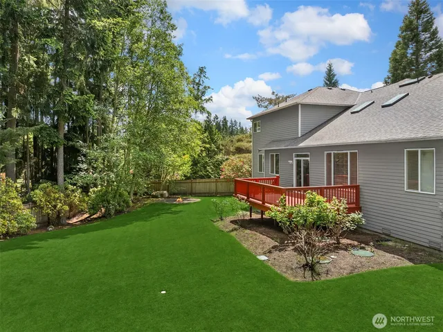 a view of house with a big yard potted plants and large tree