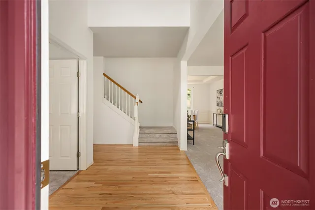 a view of a hallway with wooden floor and staircase