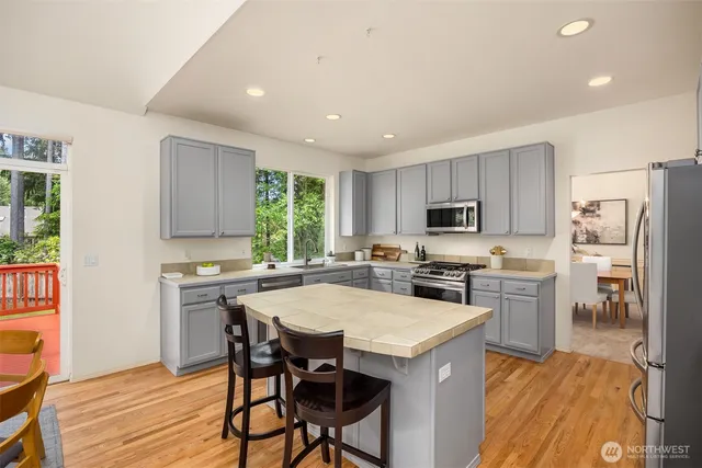a kitchen with refrigerator a stove and chairs