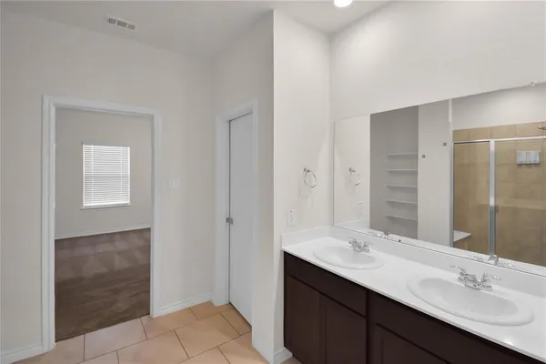 a bathroom with a double vanity sink and a mirror