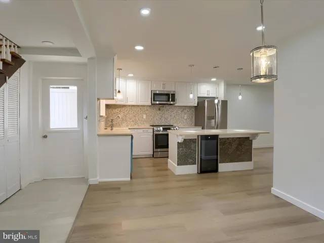 a utility room with wooden floor washer and dryer