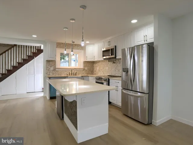 a kitchen with granite countertop a sink stove and refrigerator