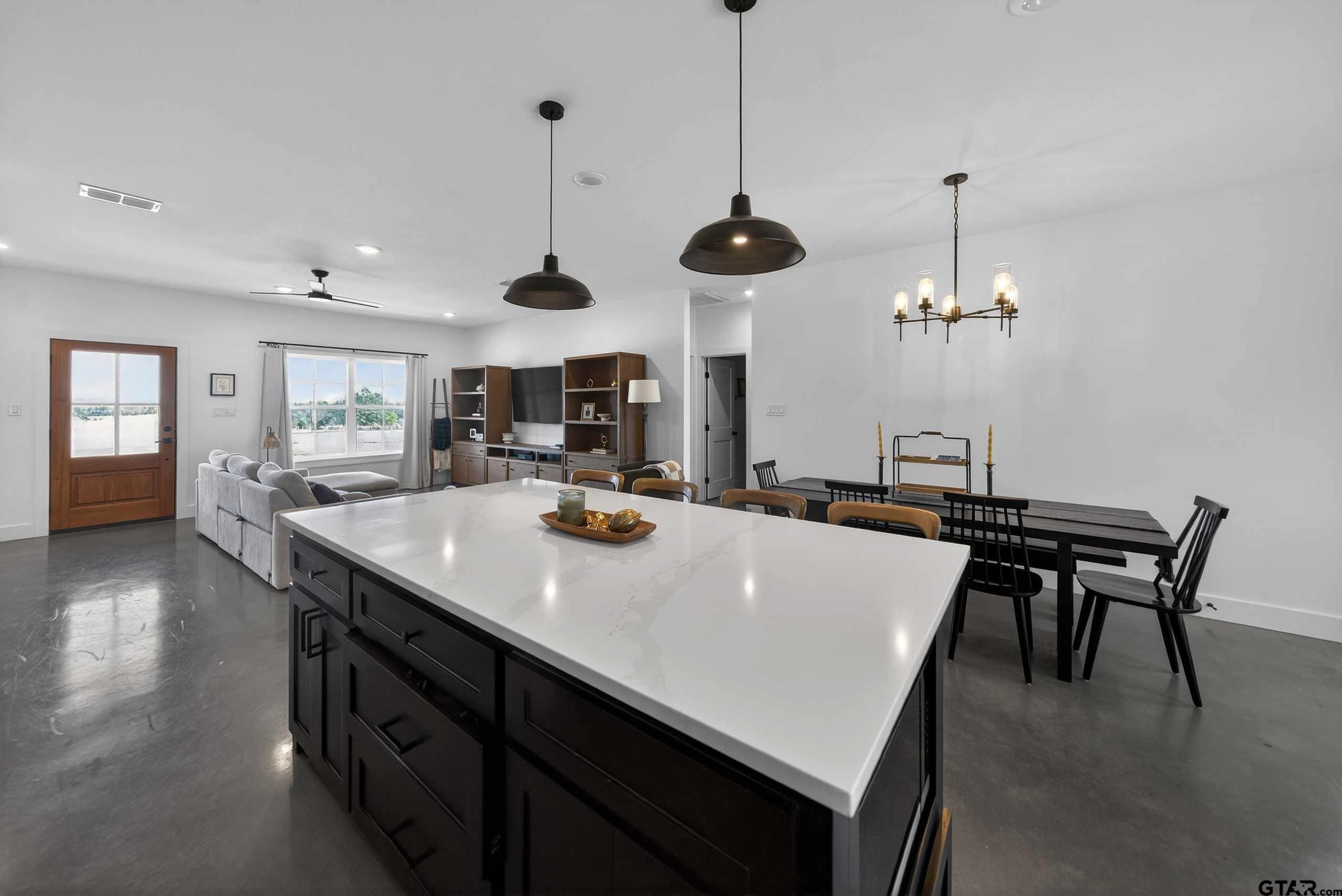 305 Gallatin Cut-Off Road Jacksonville, TX 75766 - Photo 19 of 46 a view of a dining room and livingroom with furniture wooden floor a chandelier