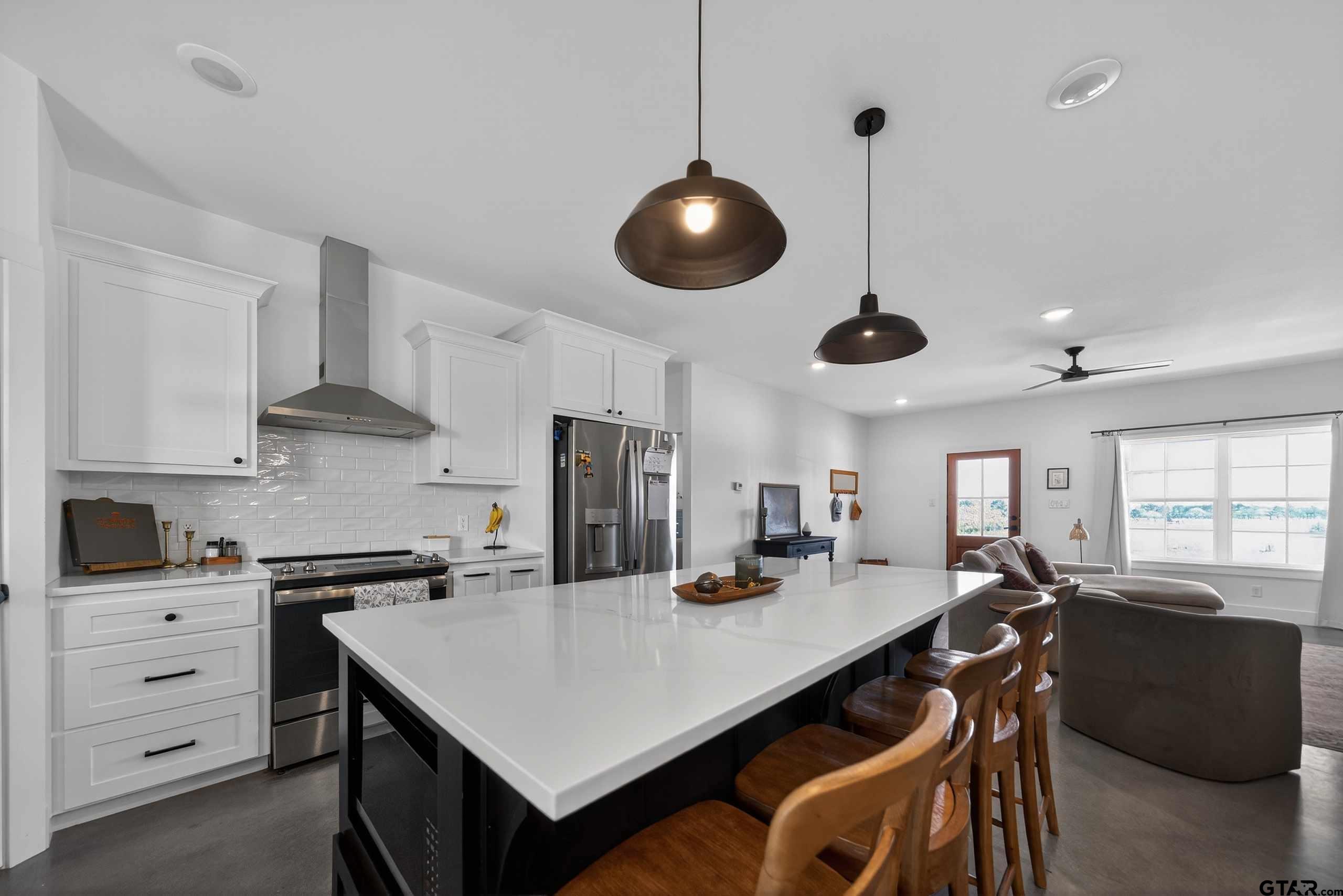 305 Gallatin Cut-Off Road Jacksonville, TX 75766 - Photo 27 of 46 a kitchen with stainless steel appliances a stove a refrigerator a sink a dining table and chairs with wooden floor