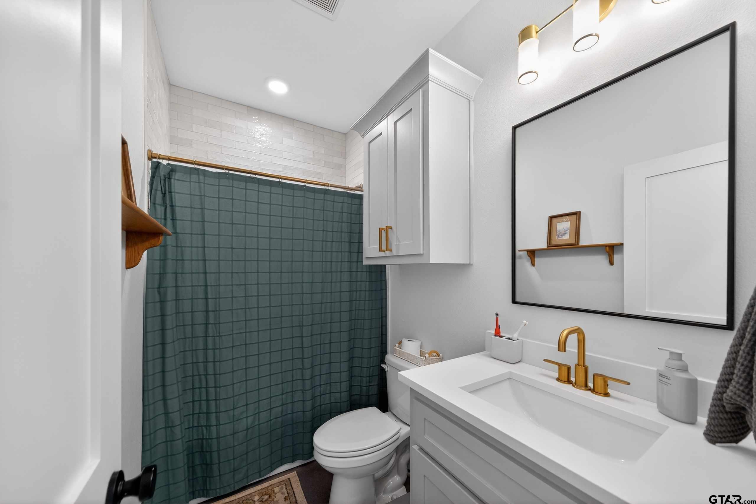 305 Gallatin Cut-Off Road Jacksonville, TX 75766 - Photo 43 of 46 a bathroom with a toilet sink vanity and mirror