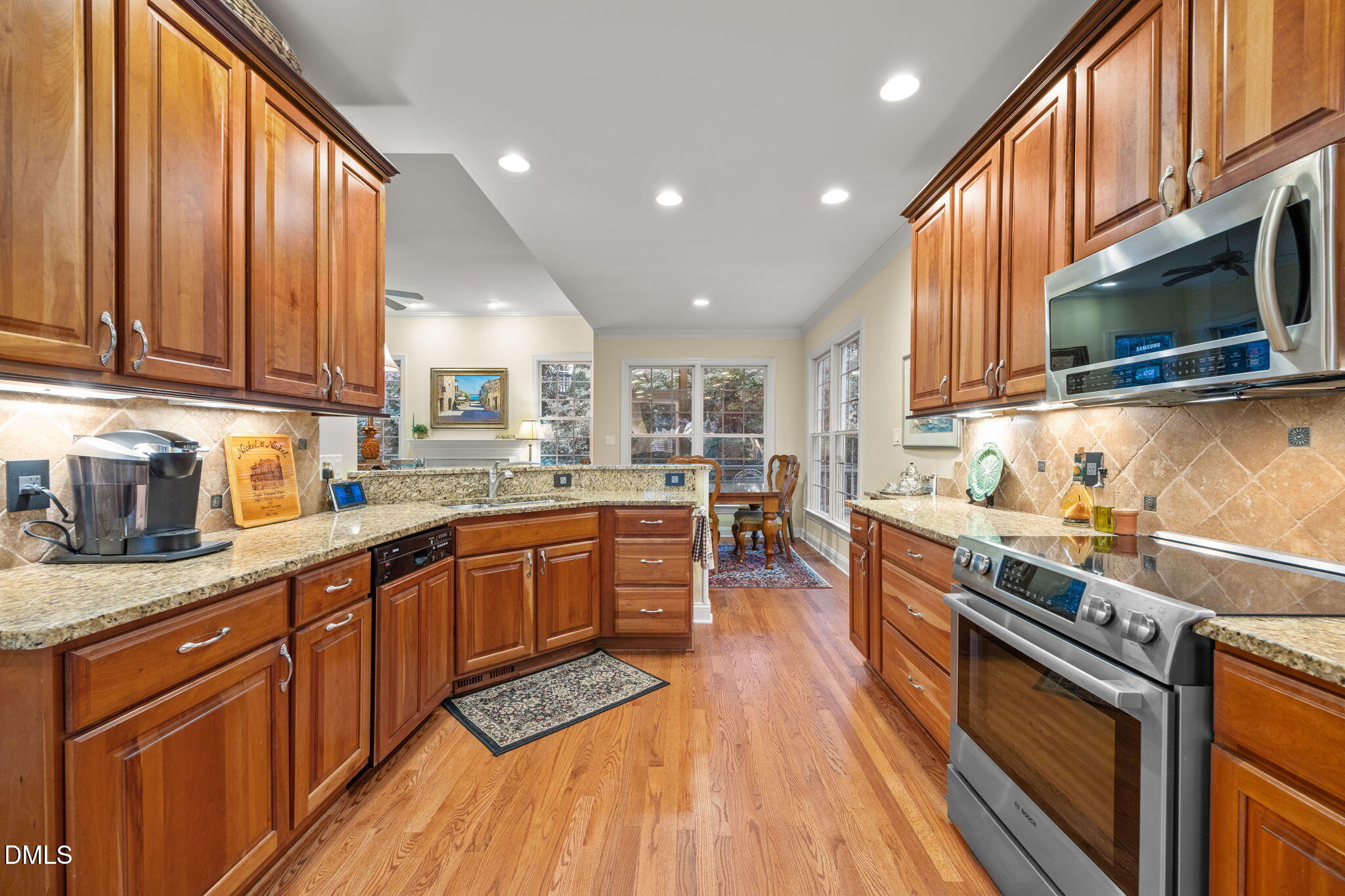 7417 Fontana Ridge Lane Raleigh, NC 27613 - Photo 8 of 54 a kitchen with stainless steel appliances granite countertop a stove a sink dishwasher and a microwave oven with wooden floor