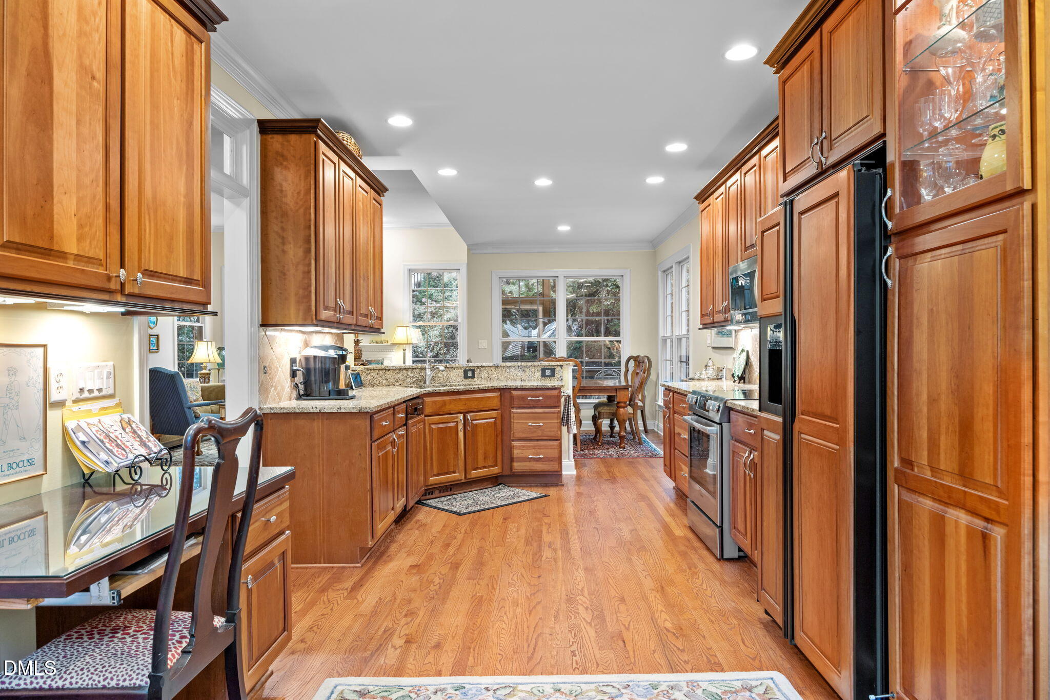 7417 Fontana Ridge Lane Raleigh, NC 27613 - Photo 9 of 54 a kitchen with stainless steel appliances kitchen island granite countertop a refrigerator a stove a sink and a dining table with wooden cabinet