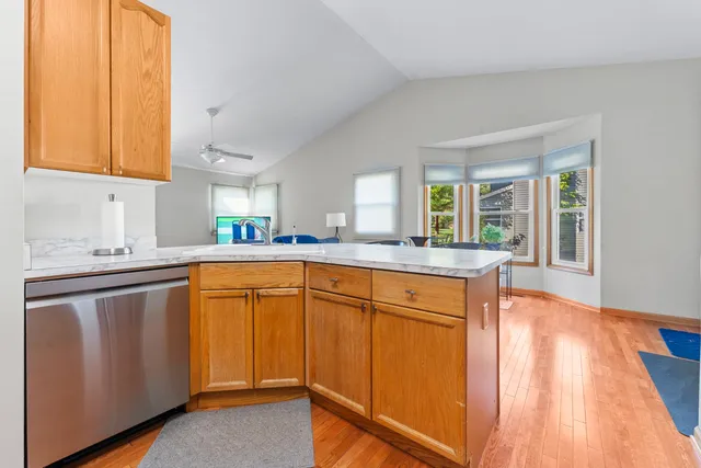 a kitchen with stainless steel appliances granite countertop wooden cabinets a sink and a large window