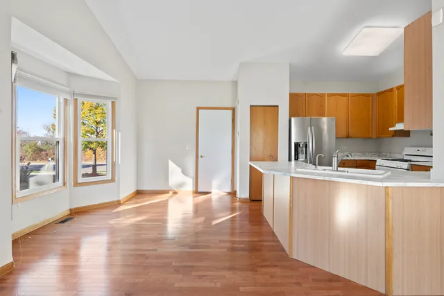 a large kitchen with stainless steel appliances a large window and a refrigerator
