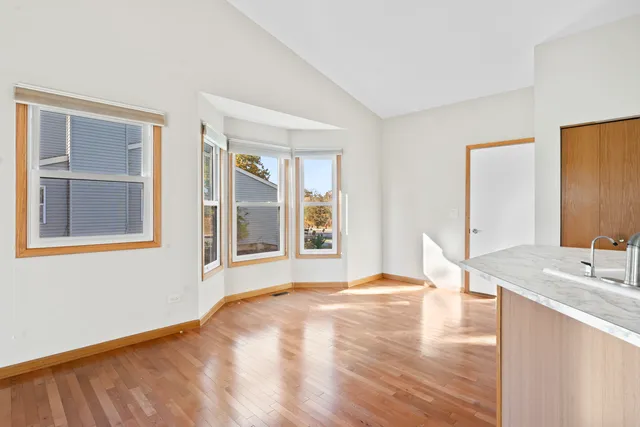 a view of a bedroom with wooden floor and a bathroom