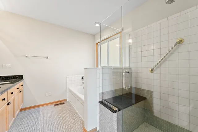 a bathroom with a granite countertop sink and a bathtub