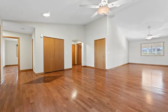 a view of an empty room with window and wooden floor