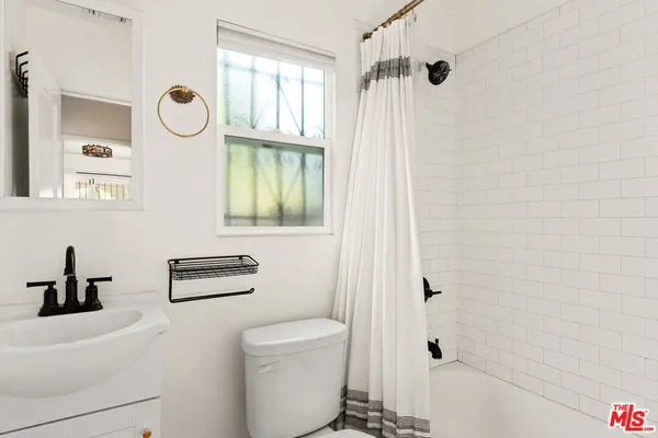 a bathroom with a toilet a sink and a shower curtain
