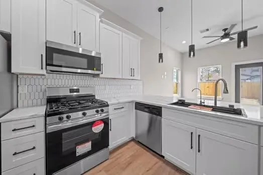 a kitchen with stainless steel appliances granite countertop a sink a stove and microwave