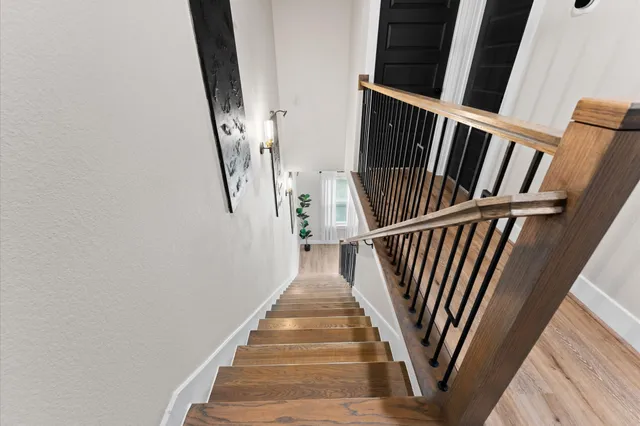 a view of staircase with wooden floor and white walls