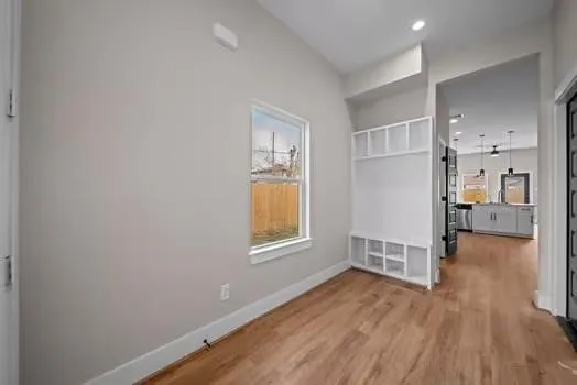 a view of hallway with wooden floor and a window