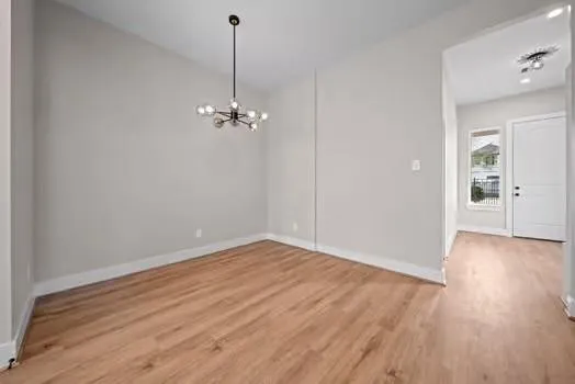 a view of a room with wooden floor and a ceiling fan