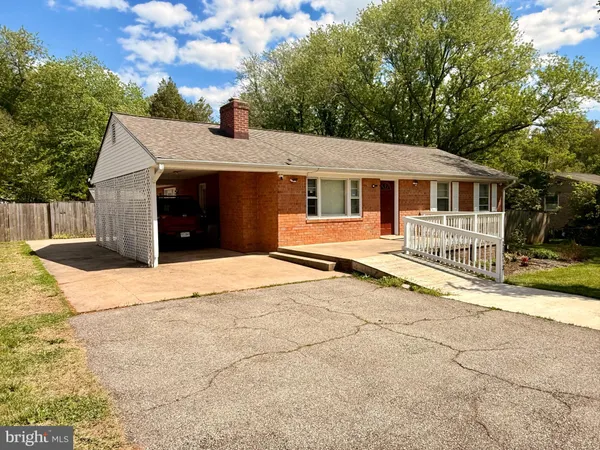 a view of a house with a yard and large tree