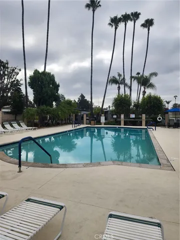 a living room with furniture kitchen view and a chandelier