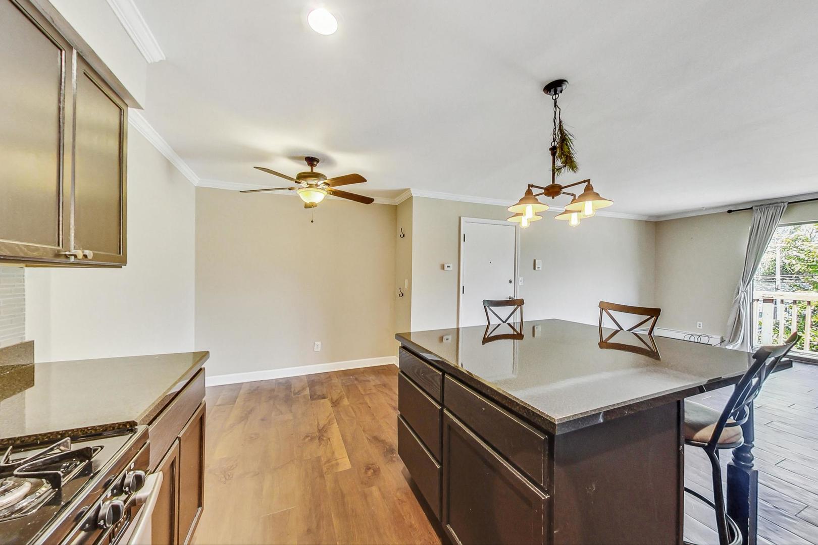 19398 Wolf Road, Unit 11 Mokena, IL 60448 - Photo 12 of 27 a kitchen with a sink a stove and chairs