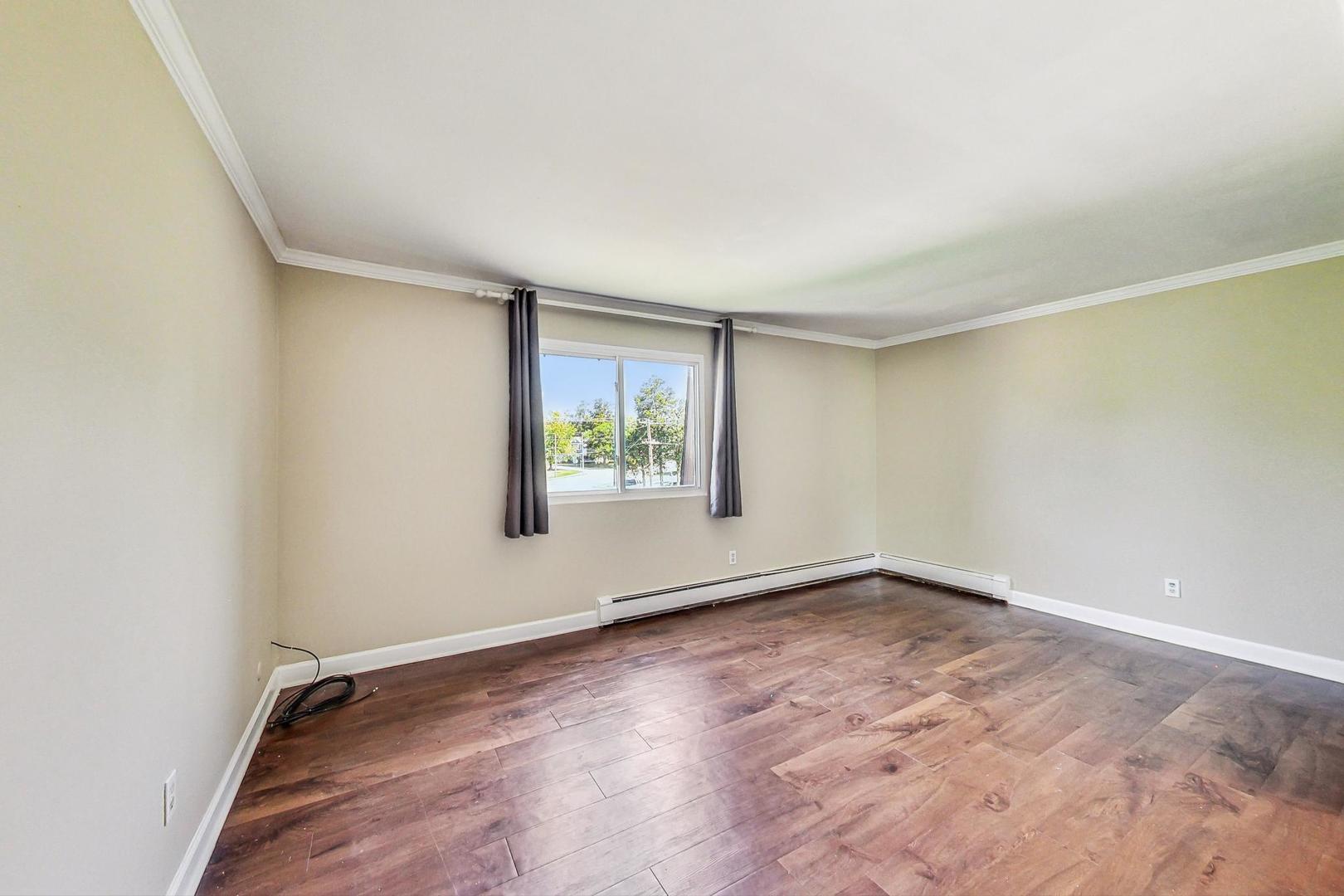 19398 Wolf Road, Unit 11 Mokena, IL 60448 - Photo 14 of 27 an empty room with wooden floor and windows