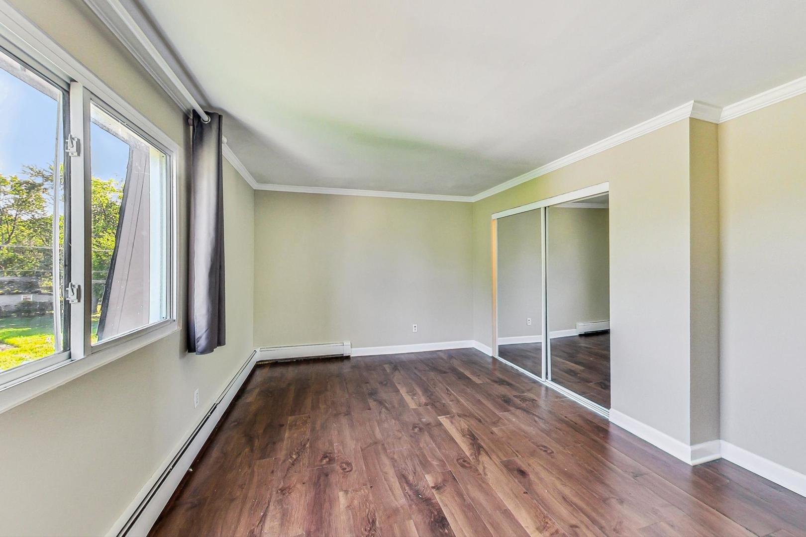 19398 Wolf Road, Unit 11 Mokena, IL 60448 - Photo 15 of 27 a view of empty room with wooden floor and fan