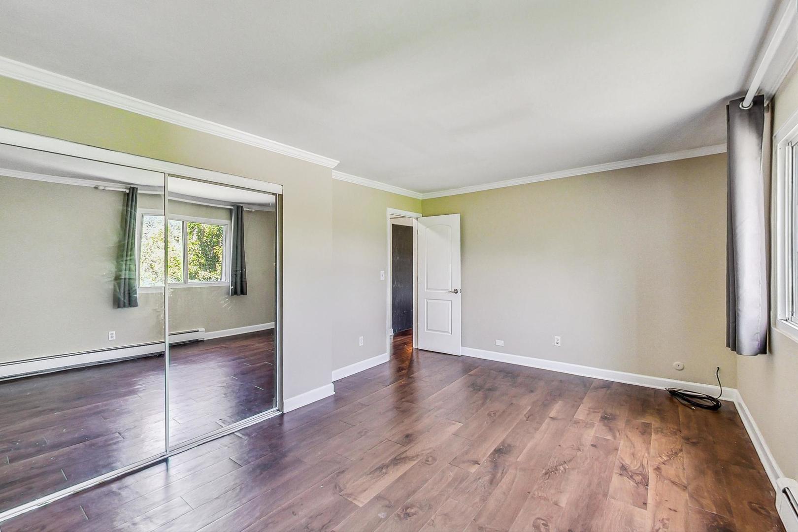 19398 Wolf Road, Unit 11 Mokena, IL 60448 - Photo 16 of 27 an empty room with wooden floor and windows