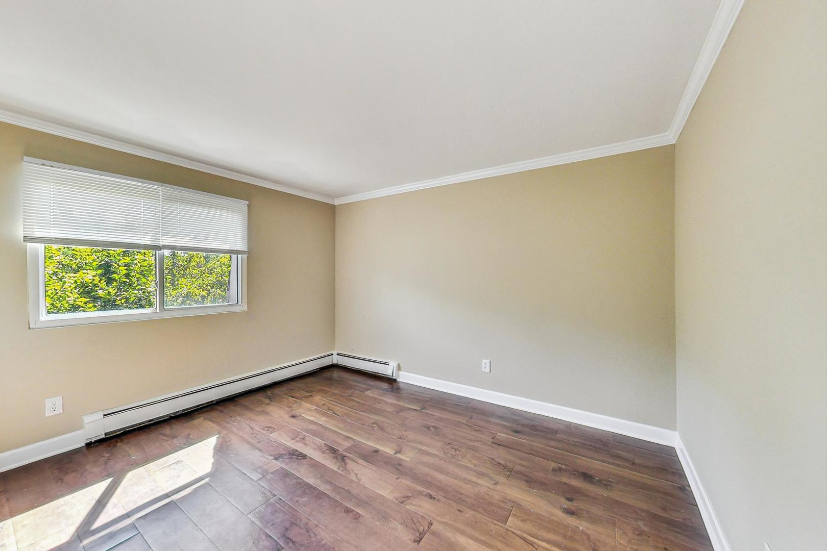 19398 Wolf Road, Unit 11 Mokena, IL 60448 - Photo 18 of 27 an empty room with wooden floor and windows