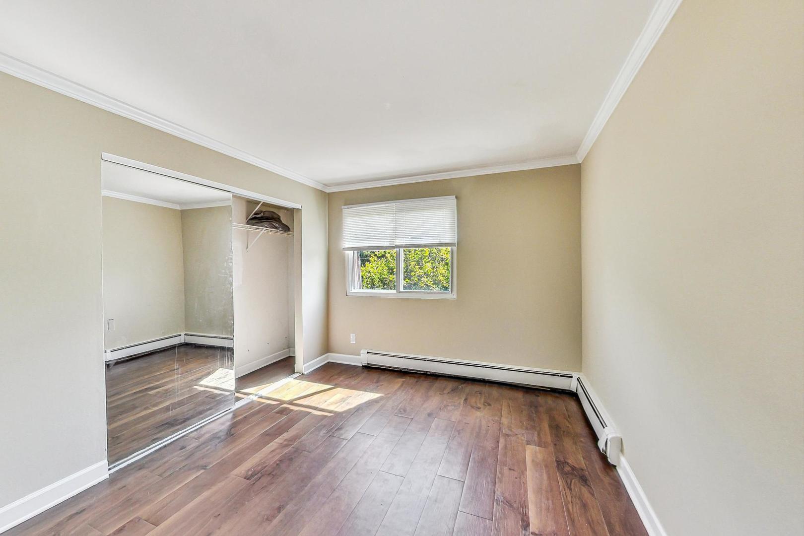 19398 Wolf Road, Unit 11 Mokena, IL 60448 - Photo 19 of 27 an empty room with wooden floor and windows