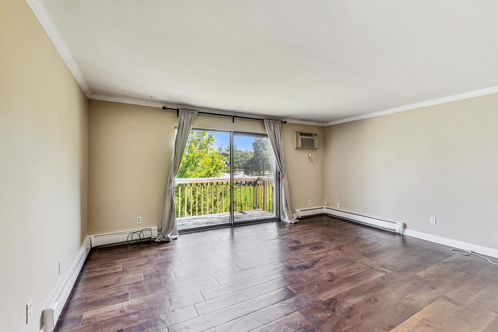 19398 Wolf Road, Unit 11 Mokena, IL 60448 - Photo 7 of 27 an empty room with wooden floor and sliding door