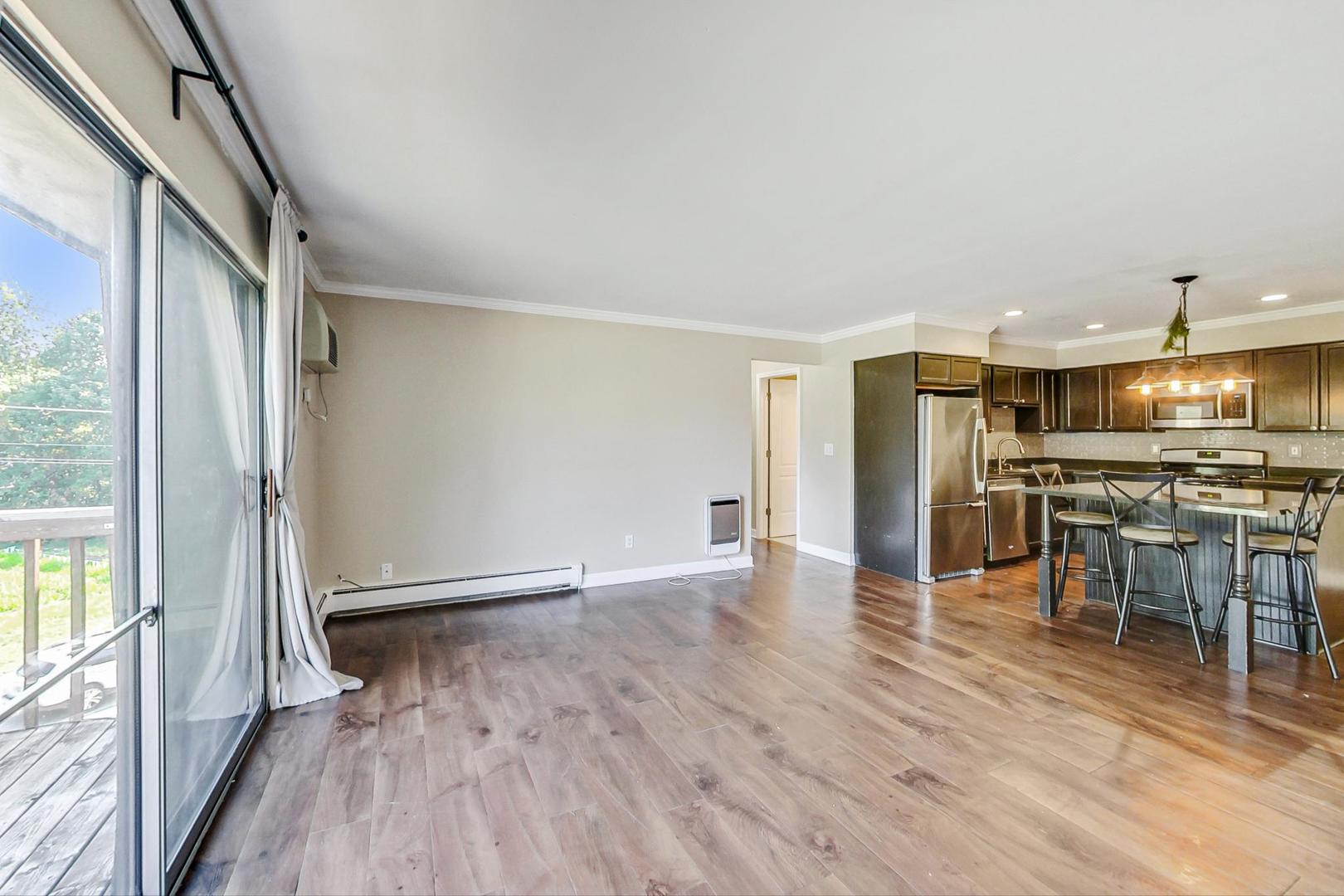19398 Wolf Road, Unit 11 Mokena, IL 60448 - Photo 8 of 27 an empty room with wooden floor and entrance to ceiling window