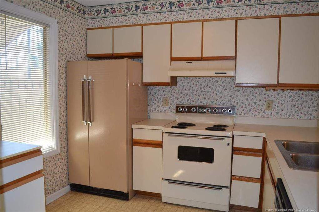 158 Cranes Cove Vass, NC 28394 - Photo 10 of 19 a kitchen with granite countertop white cabinets and white appliances