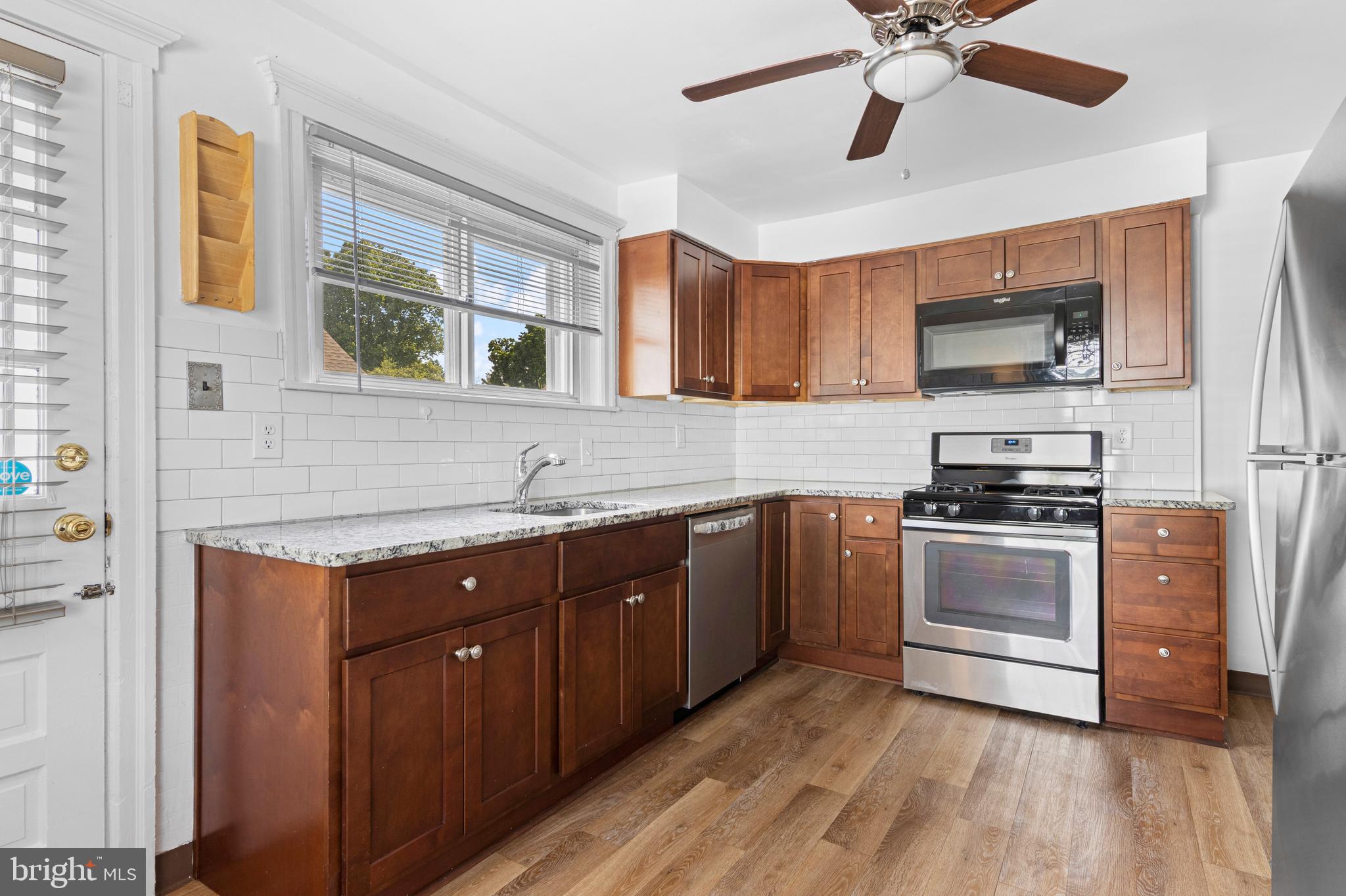 153 Conestoga Road Wayne, PA 19087 - Photo 2 of 13 a kitchen with granite countertop a sink cabinets stainless steel appliances and a window