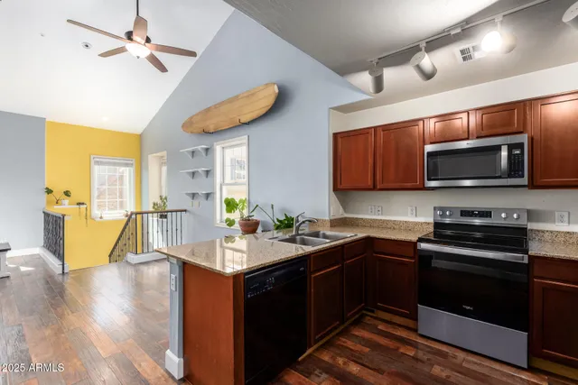 a kitchen with stainless steel appliances granite countertop a sink refrigerator and microwave