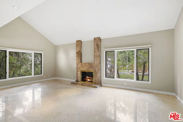a view of an empty room with a fireplace and a window