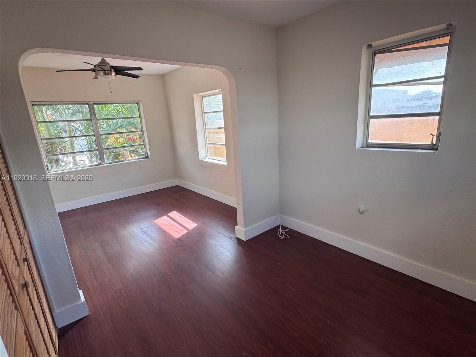 20 Northwest 17th Place, Unit 18 Miami, FL 33125 - Photo 7 of 13 a view of an empty room with wooden floor and a window