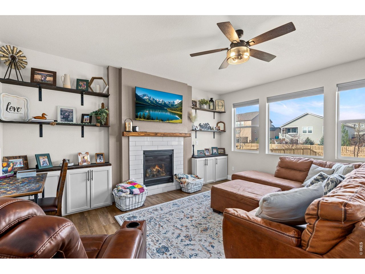 5259 Odessa Lake Street Timnath, CO 80547 - Photo 3 of 30 a living room with furniture a fireplace and a flat screen tv