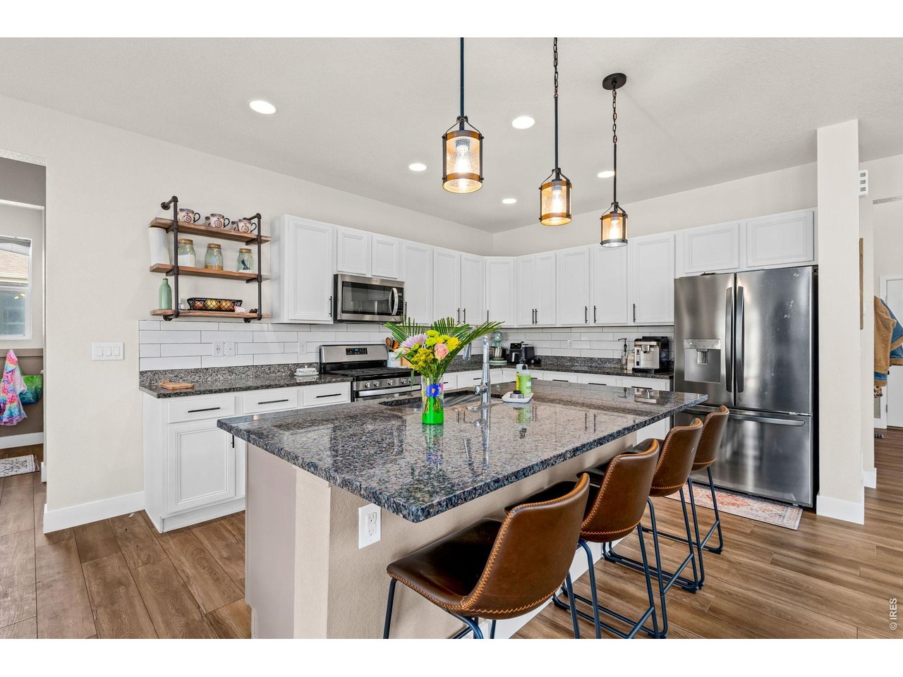 5259 Odessa Lake Street Timnath, CO 80547 - Photo 6 of 30 a kitchen with stainless steel appliances granite countertop a sink refrigerator and microwave