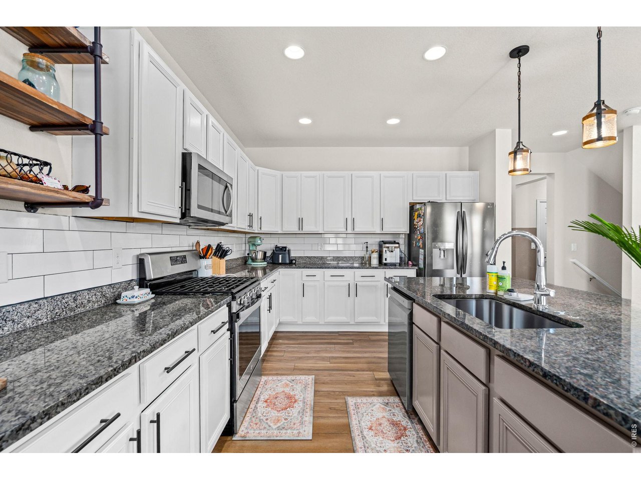 5259 Odessa Lake Street Timnath, CO 80547 - Photo 7 of 30 a kitchen with stainless steel appliances granite countertop a sink a stove and cabinets