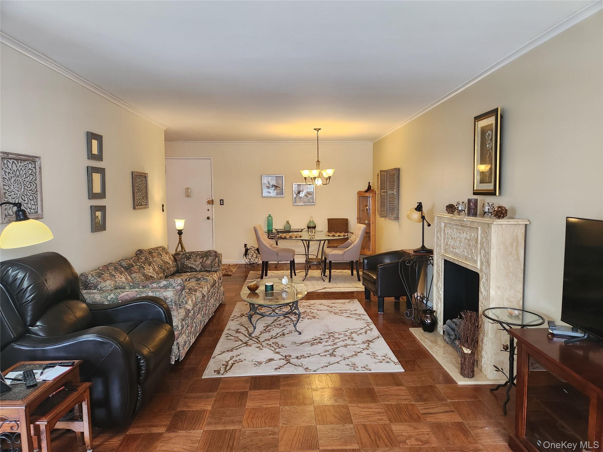 700 Shore Road, Unit 4K Long Beach, NY 11561 - Photo 6 of 31 a living room with furniture a flat screen tv and a fireplace