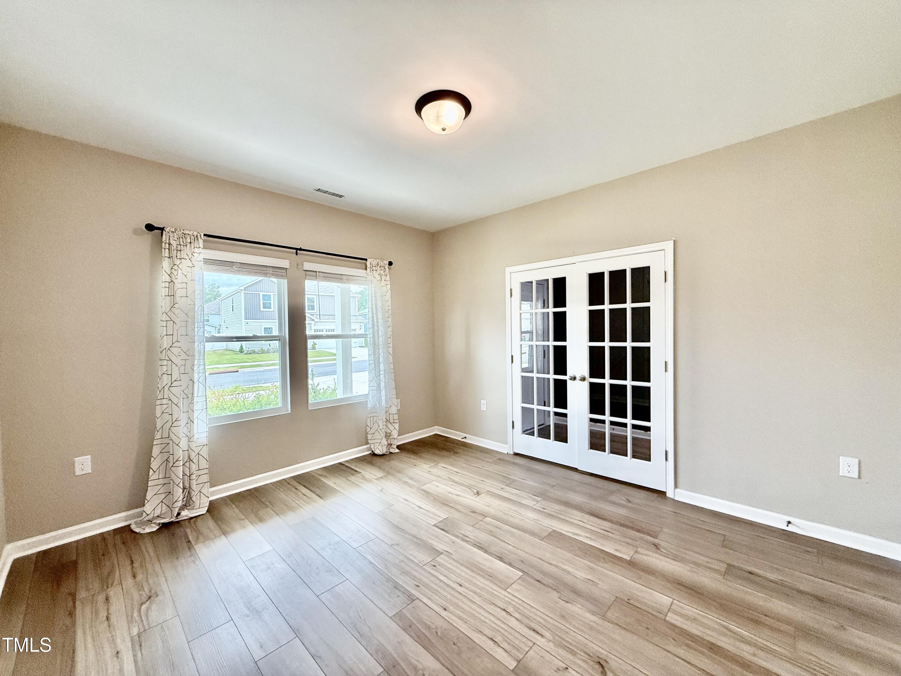 3904 Leeson Trail Raleigh, NC 27616 - Photo 14 of 43 an empty room with wooden floor and windows