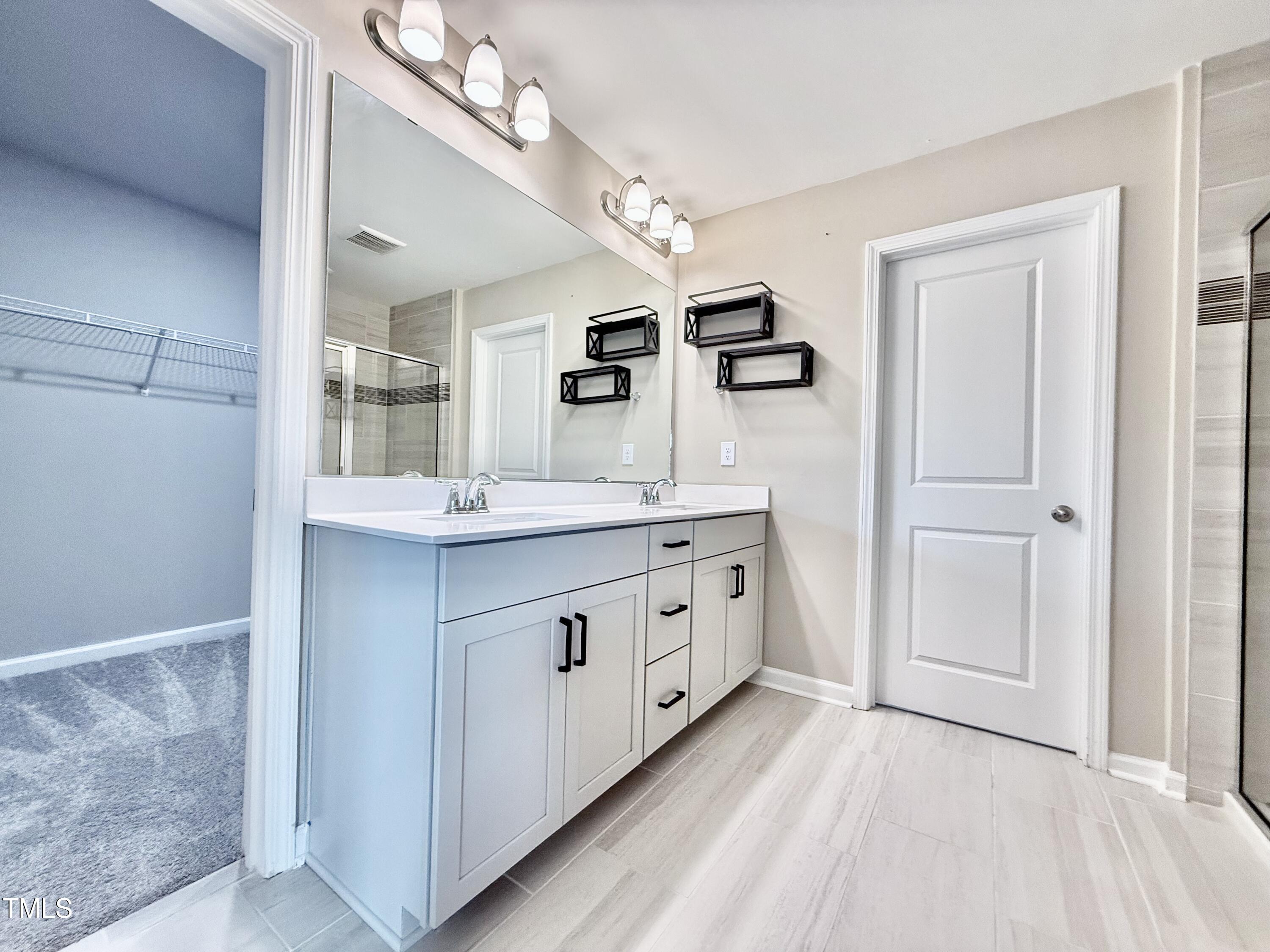 3904 Leeson Trail Raleigh, NC 27616 - Photo 28 of 43 a bathroom with a double vanity sink and mirror