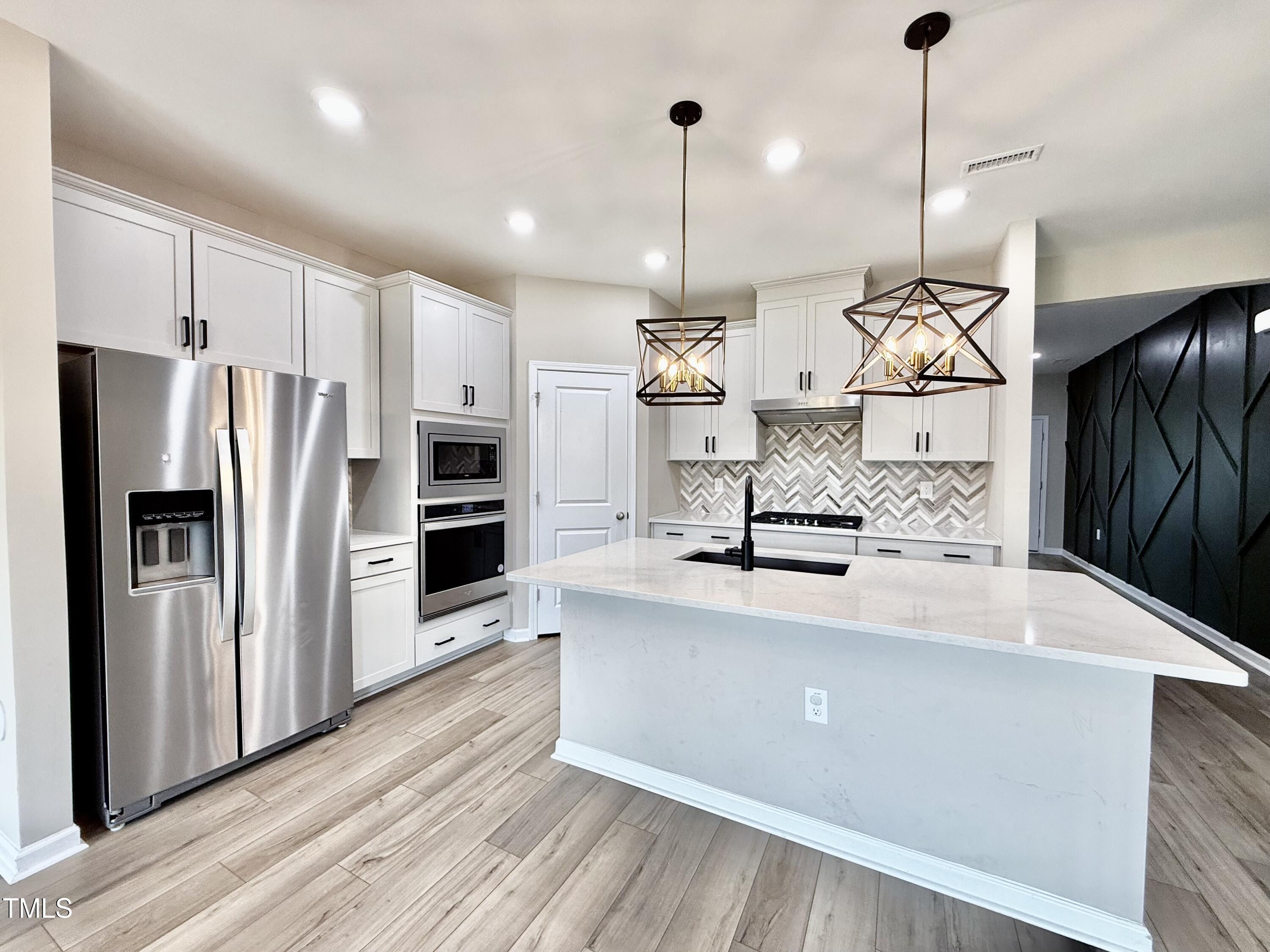 3904 Leeson Trail Raleigh, NC 27616 - Photo 8 of 43 a large kitchen with stainless steel appliances kitchen island a large counter top a stove a refrigerator and a kitchen island