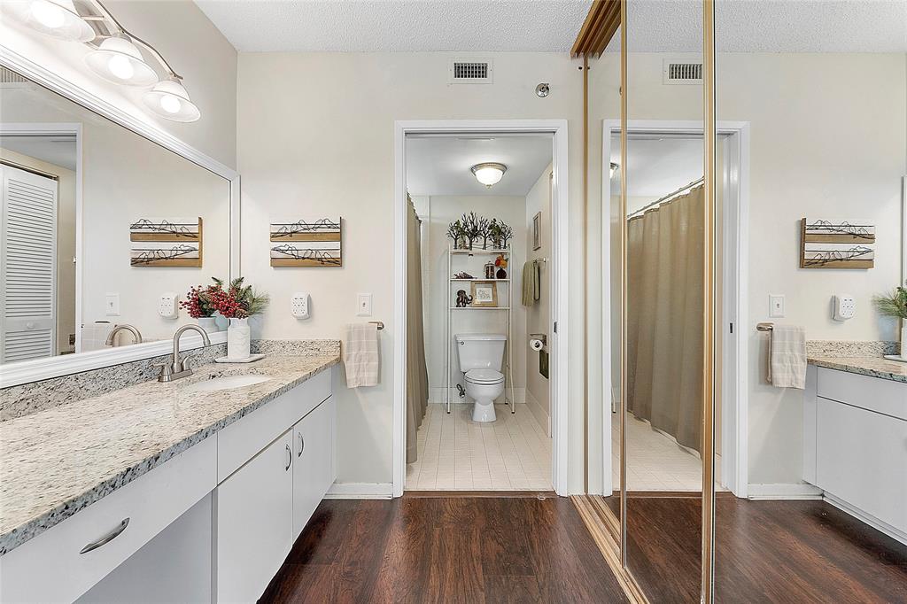 2240 North Cypress Bend Drive, Unit 908 Pompano Beach, FL 33069 - Photo 17 of 66 a bathroom with a granite countertop sink a mirror a vanity and a shower