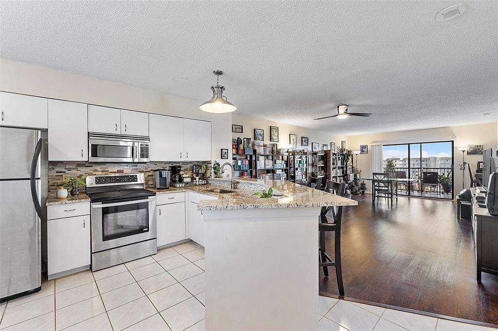 2240 North Cypress Bend Drive, Unit 908 Pompano Beach, FL 33069 - Photo 2 of 66 a kitchen with stainless steel appliances granite countertop a stove and a refrigerator