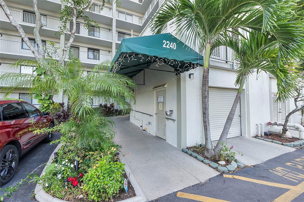 2240 North Cypress Bend Drive, Unit 908 Pompano Beach, FL 33069 - Photo 31 of 66 a front view of a house with a garden