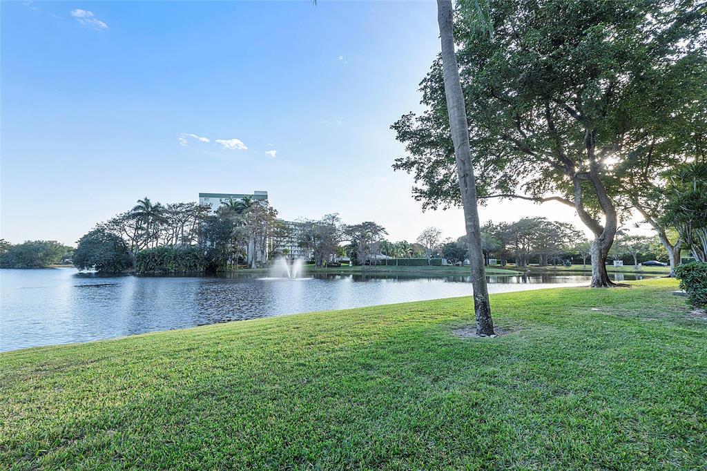 2240 North Cypress Bend Drive, Unit 908 Pompano Beach, FL 33069 - Photo 34 of 66 a view of a lake with houses in the background