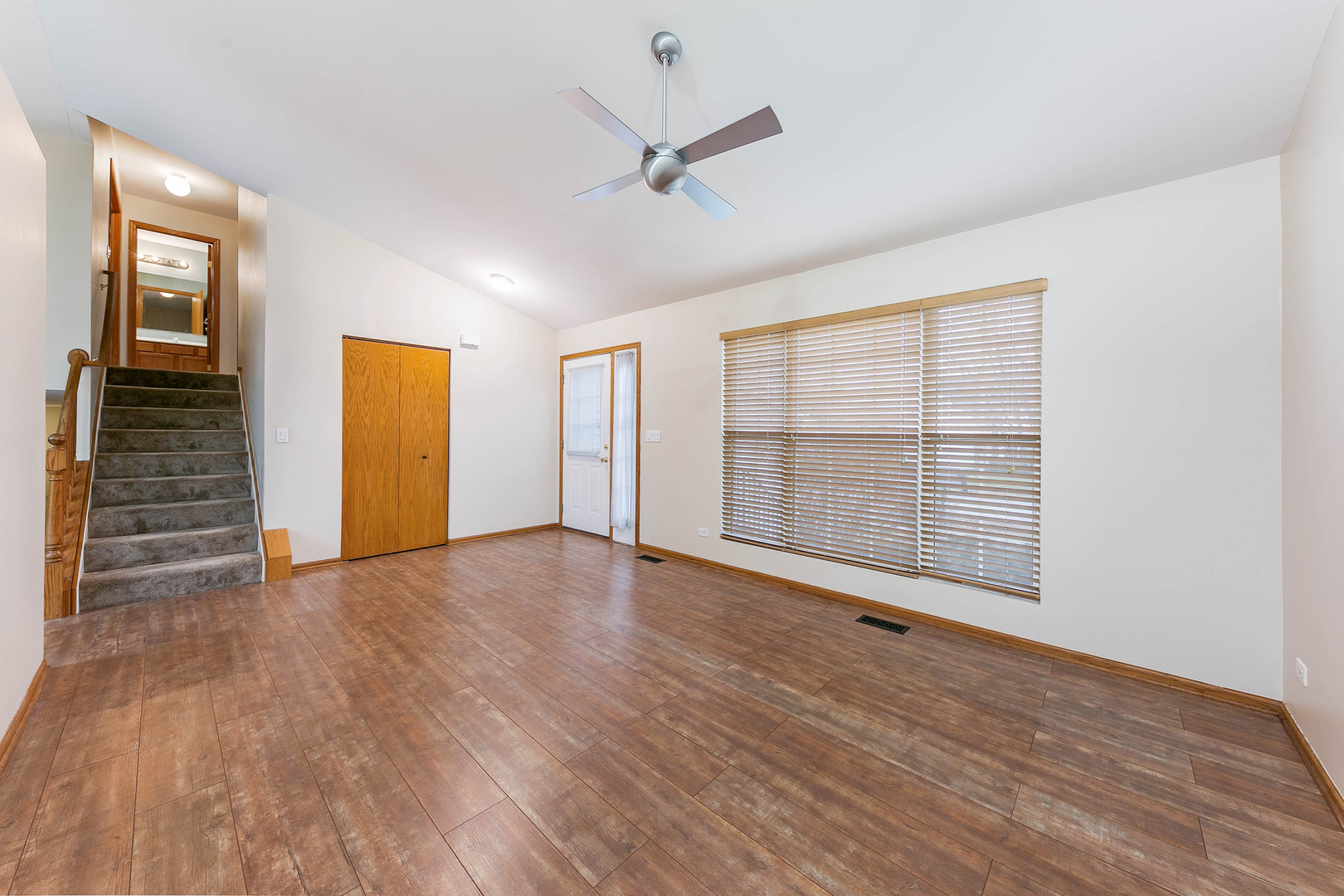 448 Bluebird Drive Bolingbrook, IL 60440 - Photo 4 of 20 a view of an empty room with a window and wooden floor