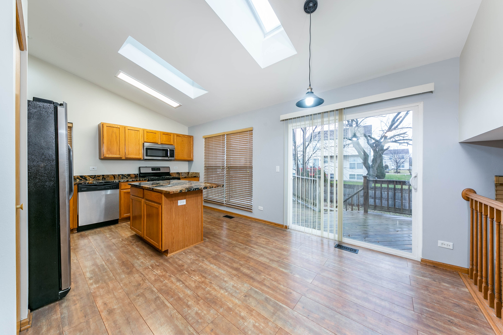 448 Bluebird Drive Bolingbrook, IL 60440 - Photo 5 of 20 a kitchen with stainless steel appliances granite countertop a stove top oven a sink with wooden cabinets and glass door