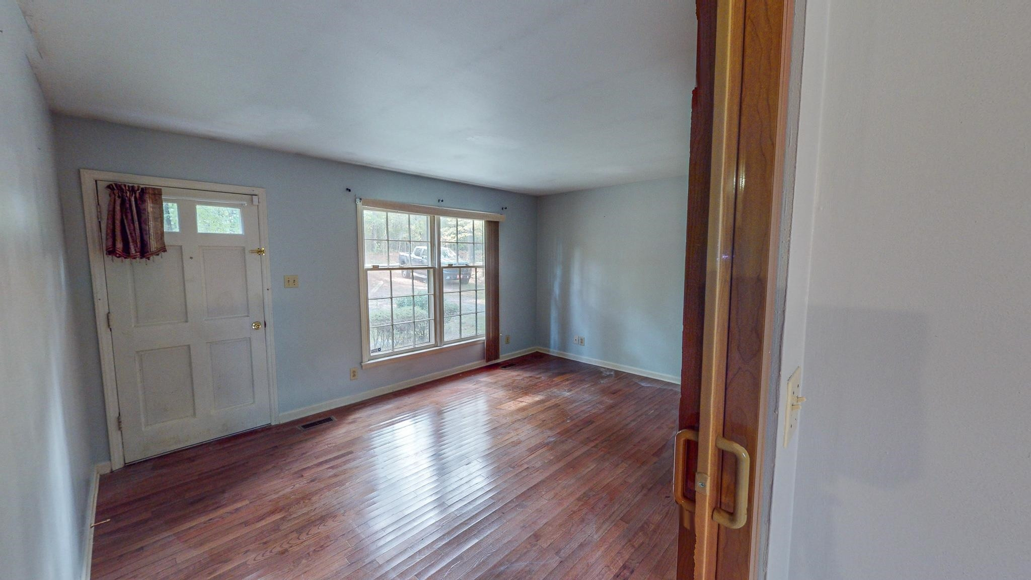 5516 Old NC 10 Durham, NC 27705 - Photo 9 of 26 an empty room with wooden floor and windows